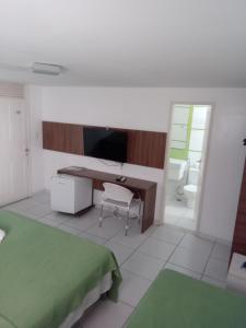 1 dormitorio con escritorio, 1 cama y baño en Pousada Familly -Praia de Tambaú -PB, en João Pessoa