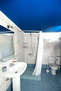 La salle de bains blanche est pourvue d'un lavabo et de toilettes. dans l'établissement Chroma, à Foinikounda