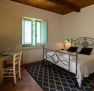 a bedroom with a bed and a desk and a window at Lo Smarrino agriturismo in Gubbio +81 photos