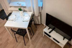a white dining room table with chairs and a television at 2ndhomes Kamppi Apartments 3 in Helsinki