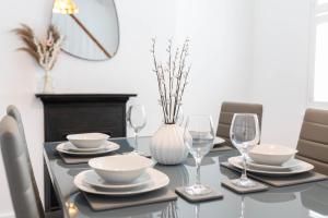 uma mesa de jantar com pratos e copos de vinho em 30 Percent Off Monthly Stays - City Centre - 3 Bedrooms em Saint Albans