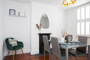 a dining room with a table and chairs and a mirror at 30 Percent Off Monthly Stays - City Centre - 3 Bedrooms in St. Albans