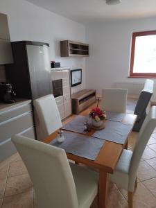 Badín的住宿－Ubytovanie Vo dvore，厨房以及带木桌和椅子的用餐室。