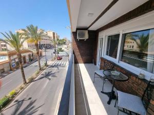 einen Balkon mit einem Tisch und Straßenblick in der Unterkunft Aguadulce, Apto nuevo 2 hab con terraza, Aire, WiFi, a 5 min de la playa in Aguadulce