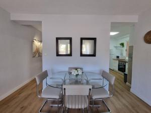 a dining room with a glass table and chairs at Santa Monica Suites, 2 hab con terraza, parking y playa a 5 min a pie in Aguadulce
