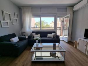 a living room with a couch and a coffee table at Santa Monica Suites, 2 hab con terraza, parking y playa a 5 min a pie in Aguadulce