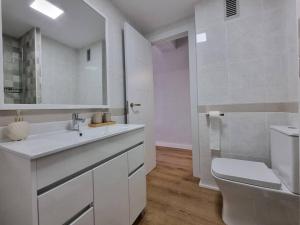 a white bathroom with a toilet and a sink at Santa Monica Suites, 2 hab con terraza, parking y playa a 5 min a pie in Aguadulce +12 photos