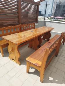 Ubytovanie Vo dvore في Badín: طاولة خشبية وكراسي على الفناء