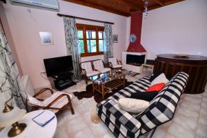 a living room with a couch and chairs and a guitar at Villa Koliri in Pyrgos
