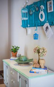 uma mesa com um armário azul e flores sobre ele em Apartments Prgomet em Makarska