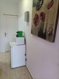 a room with a refrigerator and a painting on the wall at El Refugio in Parque Holandes