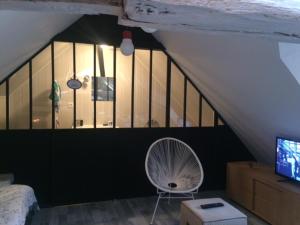 een slaapkamer met een ventilator, een bed en een televisie bij LE LOFT DU DOUBS in Besançon
