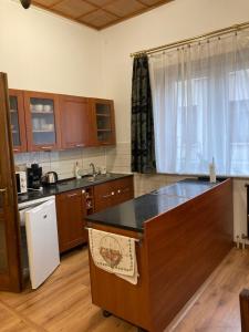 a kitchen with wooden cabinets and a counter top at Cédrus apartman in Pécel