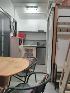 um quarto com uma mesa e cadeiras e uma cozinha em La Charmotte, tiny House insolite 