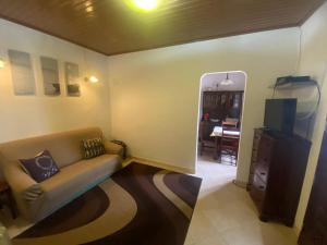 a living room with a couch and a television at Cantinho da Avó in Vila do Bispo