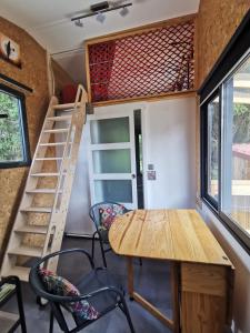 una casa pequeña con escalera, mesa y sillas en La Charmotte, tiny House insolite 