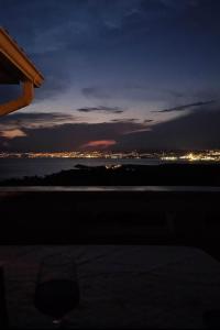 a glass of wine sitting on a table at night at Apartman Nika in Omišalj