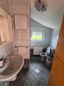 a bathroom with a sink and a toilet at Apartman Nika in Omišalj