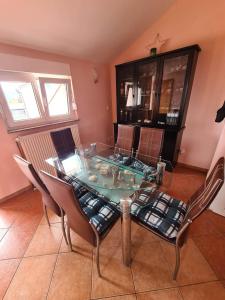 a dining room with a glass table and chairs at Apartman Nika in Omišalj