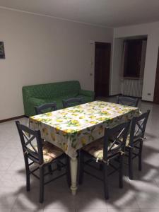 a dining room table with chairs and a table with a flower patterned table at Foresto Case Vacanza in Volta Mantovana