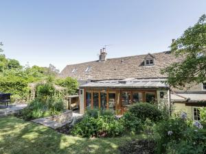an external view of a house with a garden at Fox Den Cottage in Castle Combe