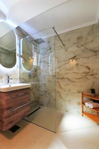 uma casa de banho com uma cabina de duche em vidro e um lavatório. em APART M top apartments close to the center em Murter