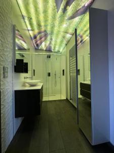 La salle de bains est pourvue d'un lavabo et d'un plafond. dans l'établissement LE COTTAGE Zen LOVE, à Foucherans