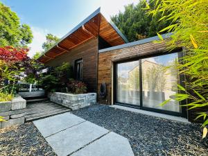 a house with glass doors and a patio at LE COTTAGE Zen LOVE in Foucherans
