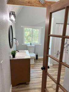 La salle de bains est pourvue de toilettes, d'un lavabo et d'une porte. dans l'établissement Modern wine country barn house, à Temecula