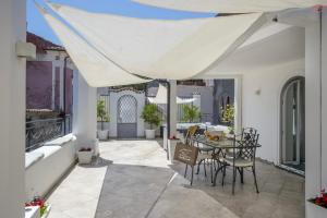 a patio with a table and chairs under a white umbrella at Ravello Vingius Suite in Ravello