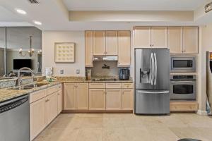 a kitchen with wooden cabinets and a stainless steel refrigerator at Indigo East 1004 in Perdido Key