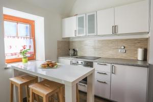 a kitchen with white cabinets and a plate of fruit on a counter at Apartmaji Tina in Zgornje Gorje
