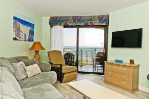 ein Wohnzimmer mit einem Sofa, einem TV und einem Balkon in der Unterkunft Wow Stunning Ocean Views at Amazing Resort in Myrtle Beach