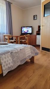 ブワディスワボボにあるPokoje gościnne LAGUNAのベッドルーム(ベッド1台、テーブル、テレビ付)