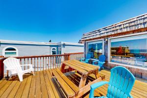 a deck with chairs and a wooden table and chairs at Pelican Harbor in Rockaway Beach
