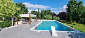 una piscina en un patio con sillas alrededor en Oltre la Siepe Apartment en Nepi
