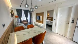 a dining room with a table and chairs and a living room at Happy Apart Hotel in Kuşadası