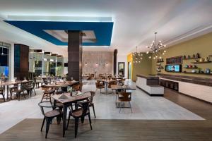 um restaurante com mesas e cadeiras e uma lareira em Four Points by Sheraton Cancun Centro em Cancún