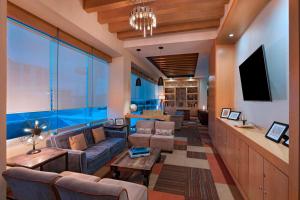 a living room with a couch and a tv at Four Points by Sheraton Cancun Centro in Cancún