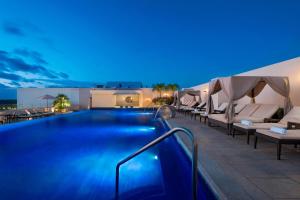 una piscina por la noche con sillas y sombrillas en Four Points by Sheraton Cancun Centro, en Cancún