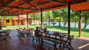 a woman sitting at a table under a pavilion at Sítio em Guriri in São Mateus