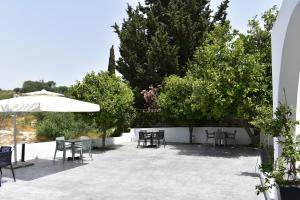 a patio with tables and chairs and an umbrella at Zoi Ayia Napa in Ayia Napa