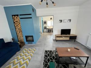 un soggiorno con tavolo e parete blu di Chatka Rybaka - wygodny dom z podwórkiem a Łeba