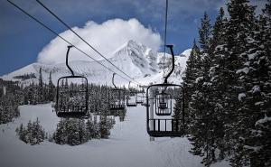 um teleférico que sobe uma montanha coberta de neve em Lone Mountain Retreat em Big Sky