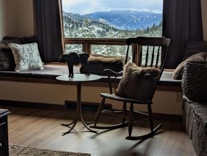 um gato sentado numa mesa em frente a uma janela em Lone Mountain Retreat em Big Sky