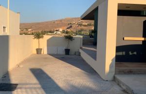 a hallway leading to a house with a hill in the background at Vrachokipos Guesthouse in Kokkini Khanion