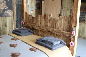 Duas camas num quarto de madeira com toalhas em The Moo-tel at Bargoed Farm em Aberaeron