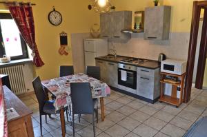 Appartamenti Luseney في Bionaz: مطبخ مع طاولة وموقد فرن علوي