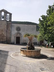 una gran fuente frente a un edificio con iglesia en B&B La casa dei nonni Assergi, en Assergi