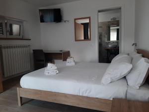 1 dormitorio con 1 cama grande con almohadas blancas en B&B La casa dei nonni Assergi, en Assergi